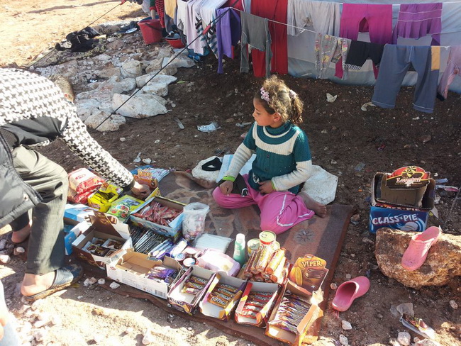 Девочка продает мелочные товары, чтобы поддержать свою семью, которая утратила отца во время бомбардировки района Алеппо, пребывающего под контролем повстанцев.