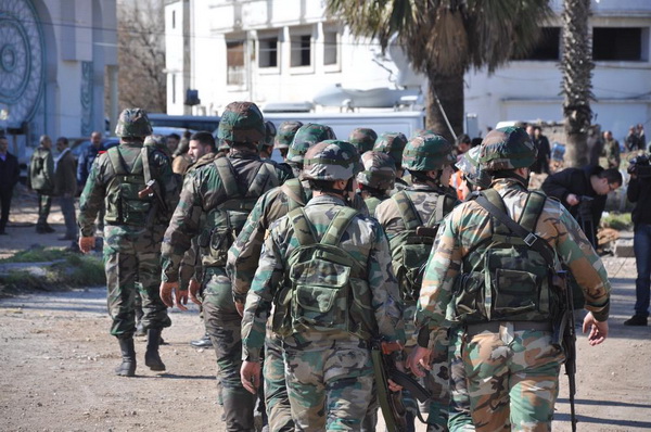 Сирийские отряды солдат собрались около того места, где автобусы высадили эвакуировавшихся, которые проживали в районах старого города, удерживаемых повстанцами.