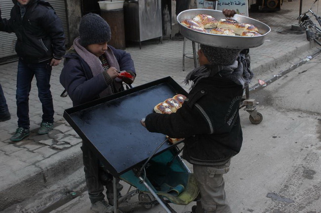 Два ребенка вынуждены продавать пончики на улице, чтобы помочь своим семьям в виду экономического коллапса на неподконтрольных правительству территориях.