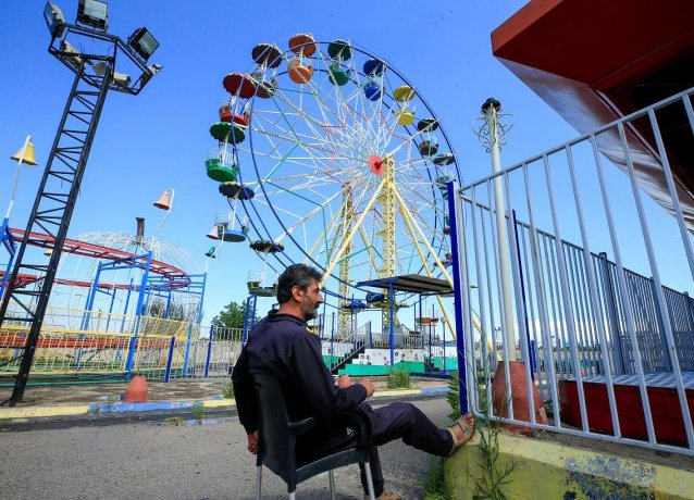 Охранник сидит в пустом парке развлечений в первый день мусульманского праздника Ид аль-Фитр в Сидоне, на юге Ливана. 